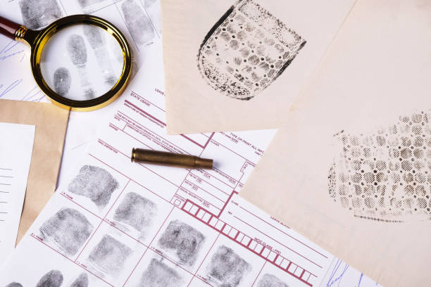 istock Forensic concept, evidence set on table, judge gavel, fictitious signature samples, spent cartridge case, shoe marks and fingerprints, top view 2172785227