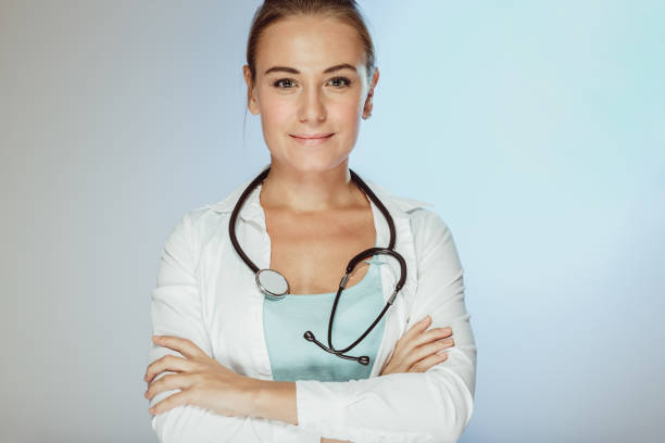 Portrait of a nice young serious doctor woman with a stethoscope isolated on clear background. Successful happy intern in a good medical clinic.