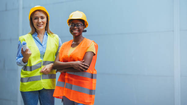 istock Female Engineers in Safety Vests and Helmets Smiling Confidently 2172786779