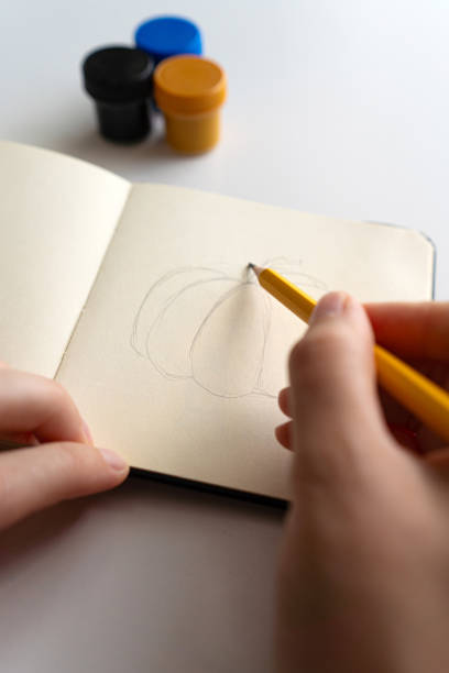 istock Starting a pumpkin sketch in a notebook with gouache 2172792991
