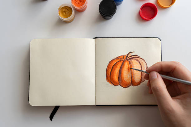 istock Finalizing a pumpkin painting with gouache in a sketchbook 2172793041