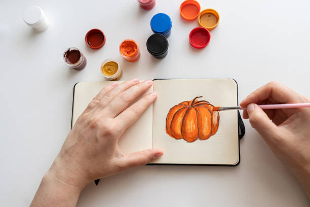 istock Finalizing a pumpkin painting with gouache in a sketchbook 2172793170