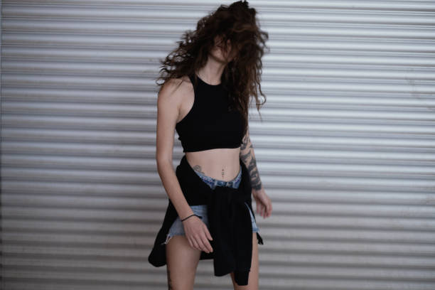 Attractive young woman standing against horizontal panel wall.