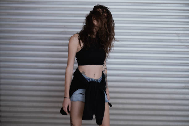 Attractive young woman standing against horizontal panel wall.
