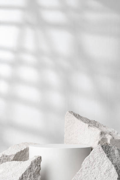 istock A minimalistic display featuring a smooth white cylinder surrounded by rough gray stone fragments 2172793465
