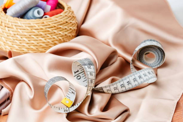 istock Colorful sewing supplies arranged neatly on a table surrounded by fabric 2172793500