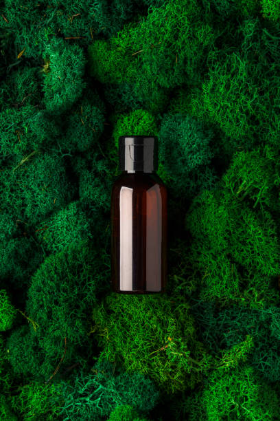 Brown glass bottle resting on lush green moss in a natural setting