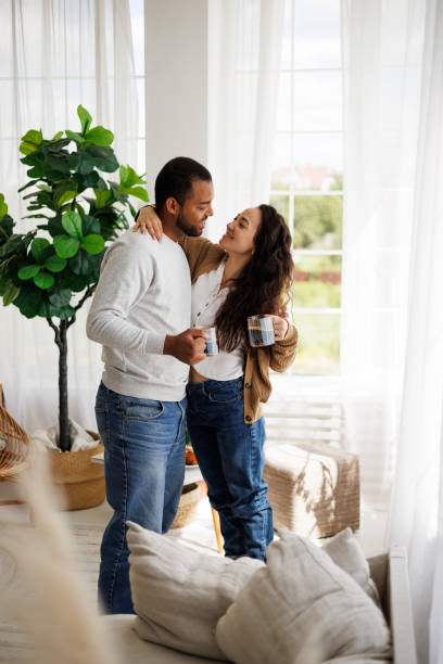 istock Interracial romantic couple with coffee hugging in morning at home 2172802896