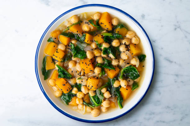 istock Chickpea stew with pumpkin and spinach. Top view table with decoration. 2172805375