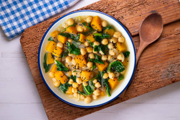 Chickpea stew with pumpkin and spinach. Top view table with decoration.