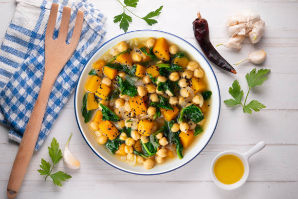 istock Chickpea stew with pumpkin and spinach. Top view table with decoration. 2172805393