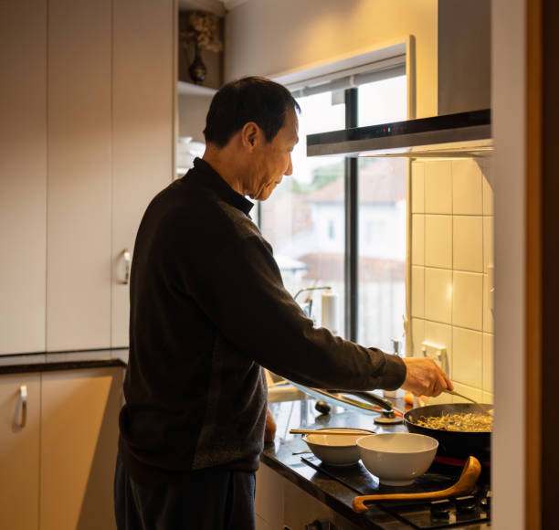 istock Man cooking dinner on the stovetop in the kitchen. 2172806136