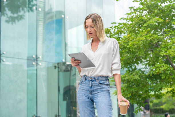 istock White Woman Using Tablet and Holding a Coffee Cup in Urban Environment 2172811719