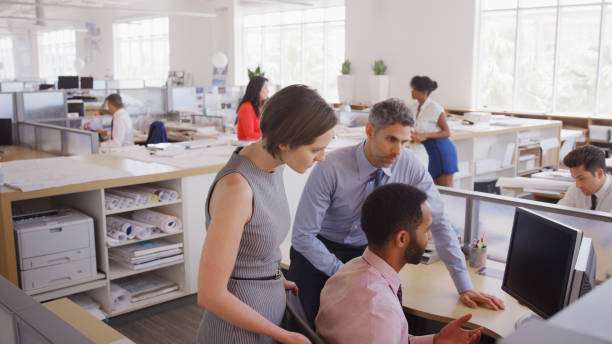 istock Multi-Cultural Business Team Meeting Around Desk In Modern Open Plan Architects Office Together 2172811823