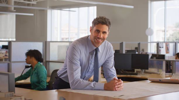istock Portrait Of Mature Male Architect In Modern Open Plan Office Studying Building Plans Or Drawings 2172811893
