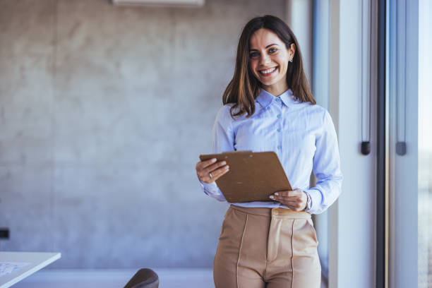 istock Confident Businesswoman Holding Clipboard in Modern Office Setting 2172815954
