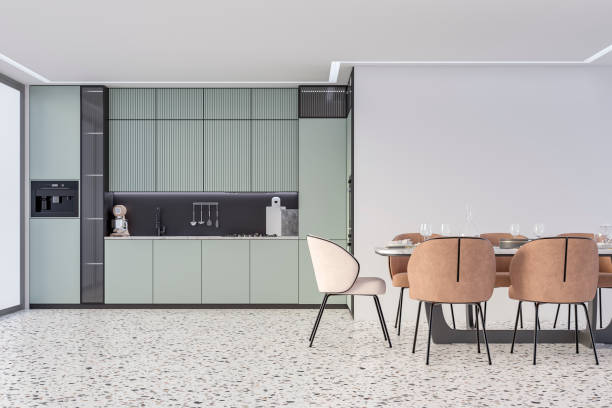 istock Modern light pastel green kitchen with a full dining table, and beige and camel brown leather chairs in front of an empty white wall with copy space, on terrazzo floor, a large window on a side stock photo 2172822252