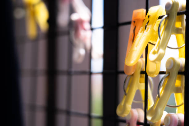 Close-up of a plastic clothespin on a grid with a blurred background light.