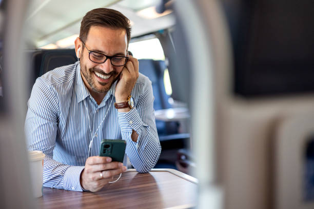 istock Happy Man Listening to Earphones and Using Smartphone on Train 2172829393