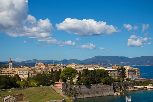 Kerkyra (Corfu) is  surrounded by crystal-clear waters and boasts a charming blend of Venetian, French, and British influences, reflected in its elegant architecture and narrow, cobbled streets.