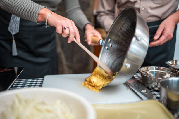 Multiracial group experience and learn the art of Chinese cuisine as they skillfully put the stir-fried egg on the chopping board for a flavorful vegetable stir-fry delight on a cooking class with beautiful Chinese female chefs.