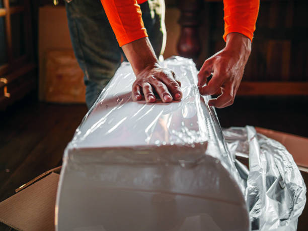 istock Workers tear off the plastic covering the Fan Coil Unit before installing it. 2172835113