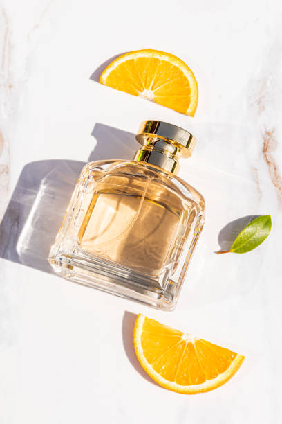 istock A elegant perfume bottle with the aroma of citrus fruit notes on an marble background with slices of orange. vertical top view. blank bottle mockup 2172836795