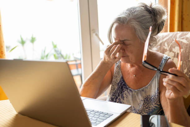 Senior woman feeling eye strain after using laptop