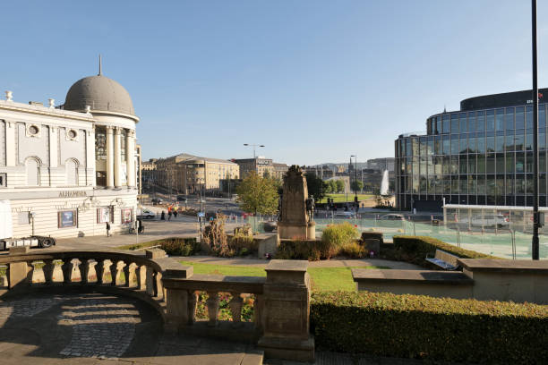 Bradford, UK 09 17 2024 View of central Bradford from behind a war memorial looking towards the City Park. The domed Alhambra theatre on the left, and modern office block on the right.