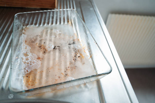 istock Dirty Glass Tray Being Cleaned in Kitchen Sink 2172844552