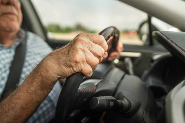 istock Hands of senior man grip steering wheel while driving during road trip 2172845480