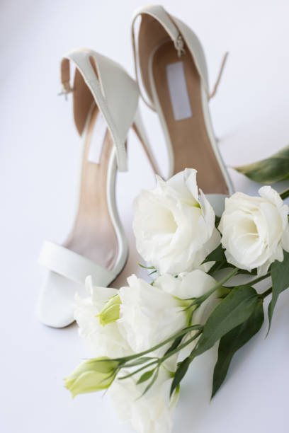 istock White wedding shoes with white flowers. 2172852133