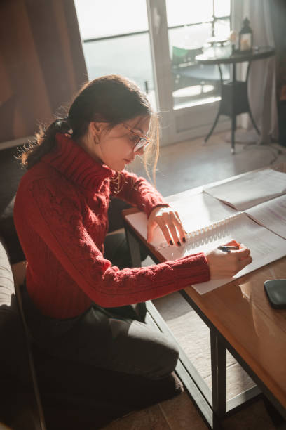 istock A lovely young girl is studying at home 2172858080
