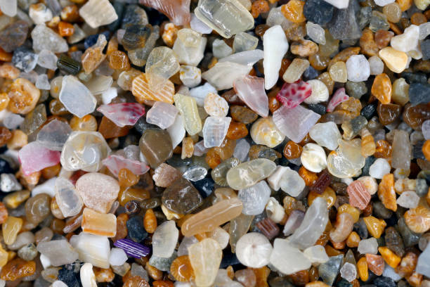 istock Macro photograph of beach sand with tiny shells, colorful stones and a tiny diamond. 2172858642