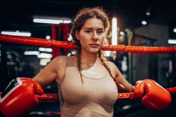 istock Female boxer resting on ropes with focused gaze. 2172859297