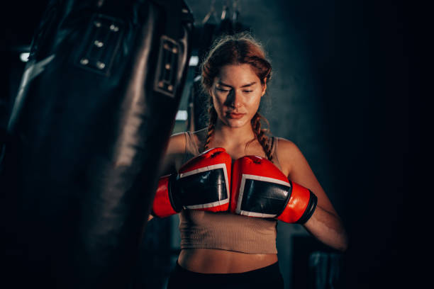 istock Focused female boxer training with gloves in gym 2172862262