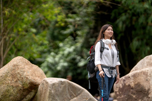 istock Woman with backpack hiking at rainforest river 2172862355