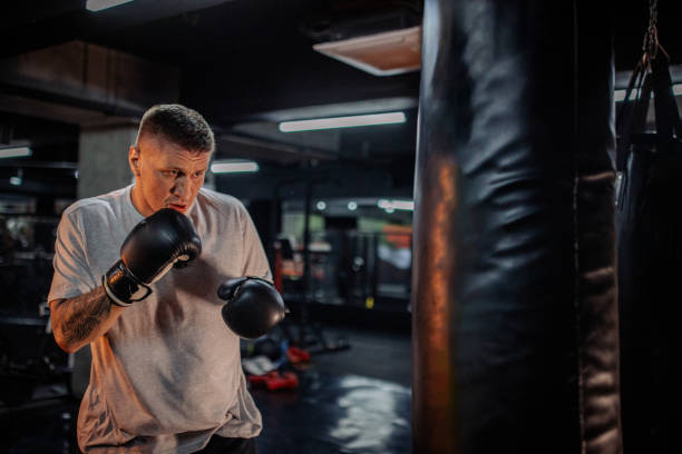 istock Boxer in action, aiming powerful punches at heavy bag. 2172864120