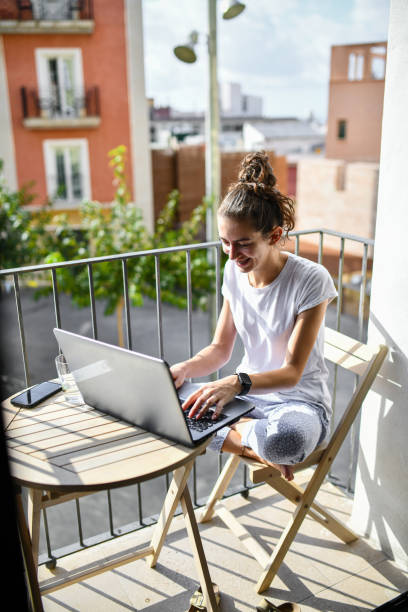 istock Graphic design project on a laptop as a female relaxes on a Valencia balcony 2172864769