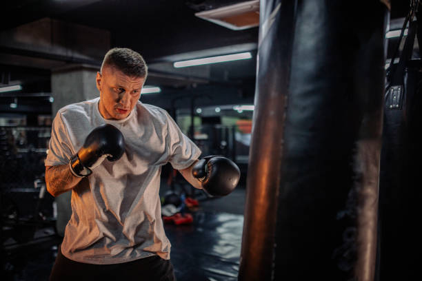 istock Boxer poised, targeting at heavy bag during workout. 2172865061