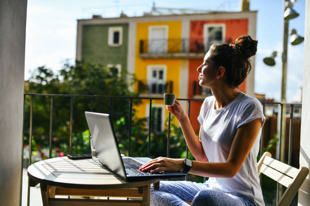 istock Remote work and coffee: Female freelancer on a balcony with laptop 2172865450