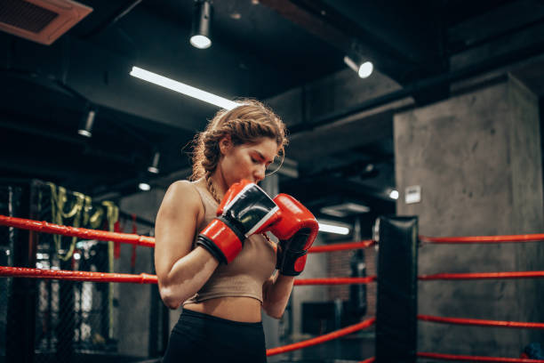 istock Boxer with red gloves in ready stance in boxing ring. 2172866754