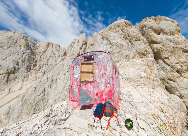Gran Sasso, Italy - 8 September 2024 - The extreme trekking to red Bivacco Bafile refuge, above 2700 meters in Abruzzo region, with alpinistic Ferrata Bafile ferris climbing ways. Here in particular a view of the exterior of Bivacco
