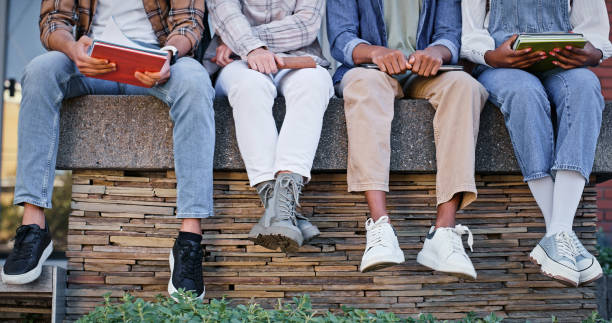 istock Feet, students and wall with book at school for education, learning support and studying of growth development. People, legs and rest for knowledge, university and reading for morning information 2172873420