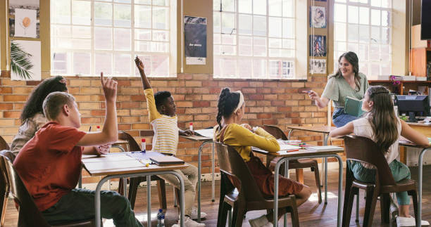 istock Students, children and teacher talking, answering questions and having a class discussion during a lesson at school. Inspired, happy and smiling educator teaching, tutoring and educating her learners 2172874634