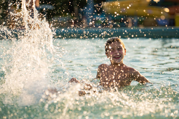 istock Happy boy splashing whit water in swimming pool 2172875685