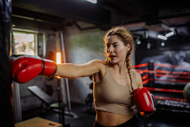 istock Woman practicing boxing with gloves in a gym 2172876498