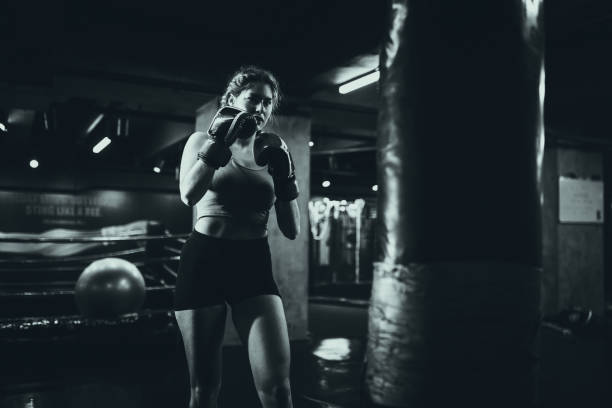 istock Woman sparring with boxing gear in gym setting 2172877214