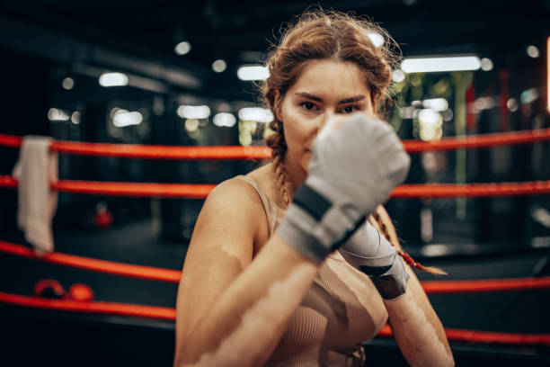 istock Woman training intensely in boxing ring, focused stance 2172877635