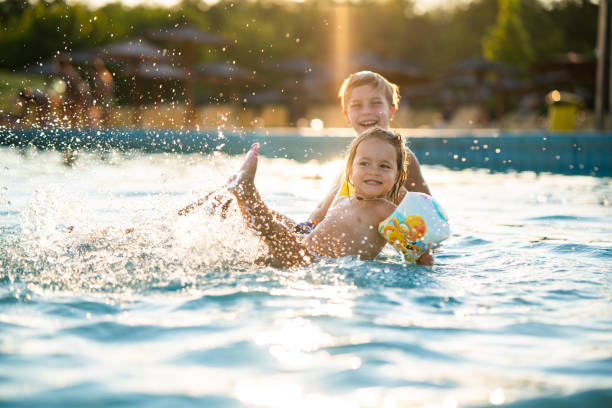 istock Children splashing with water in the pool 2172878639